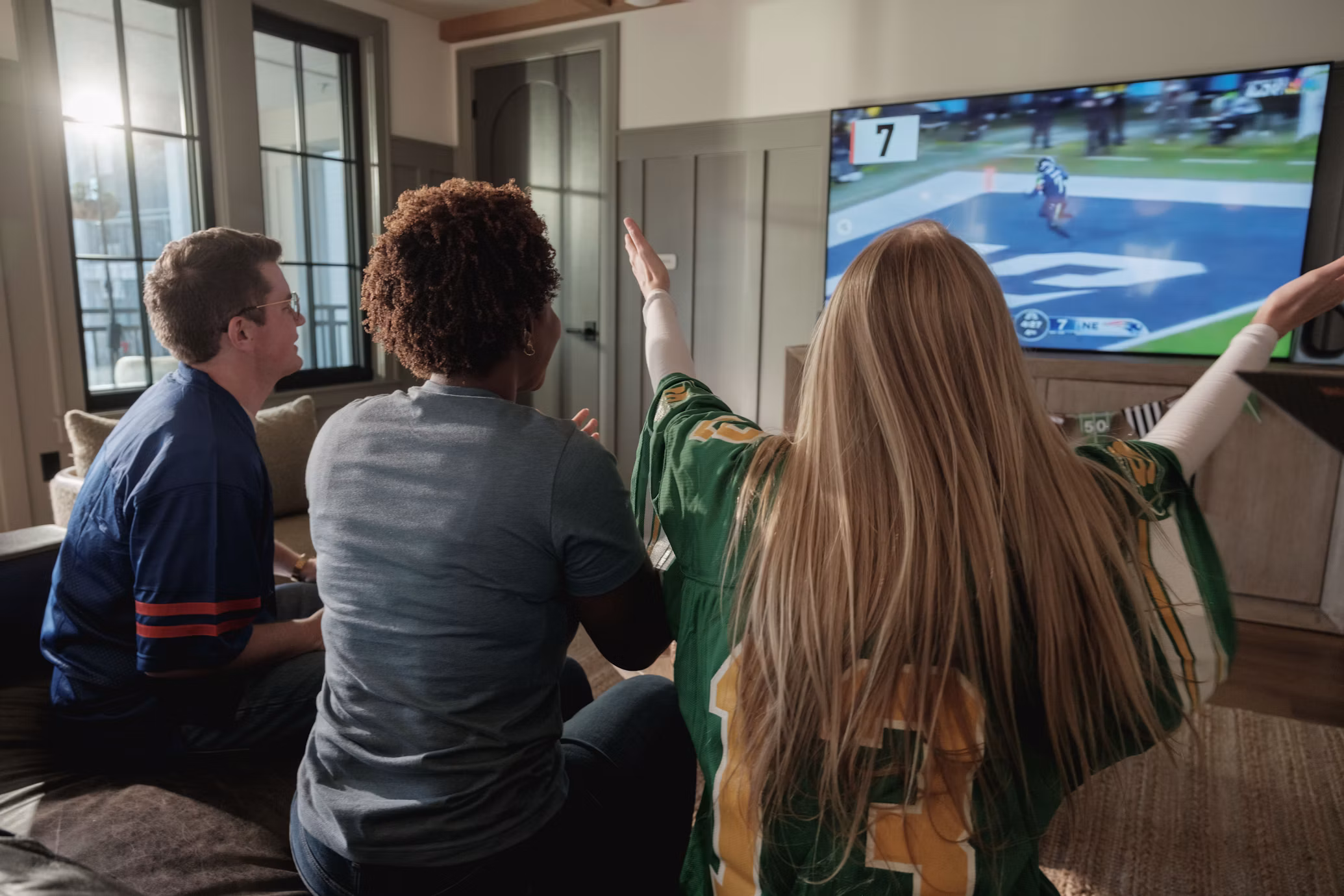 Freunde schauen Live-Sport auf dem Fernseher im Wohnzimmer